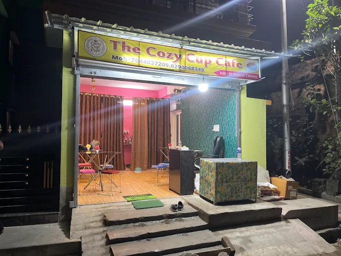 The Cozy Cup Cafe storefront at night